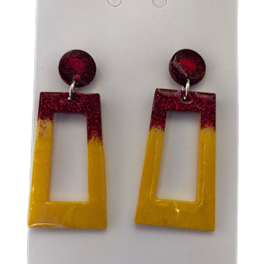 Pair of earrings with red glitter and yellow gradient on a white card